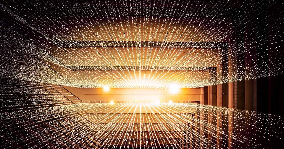 Estructura arquitectónica iluminada con miles de puntos de luz que convergen hacia un mismo eje