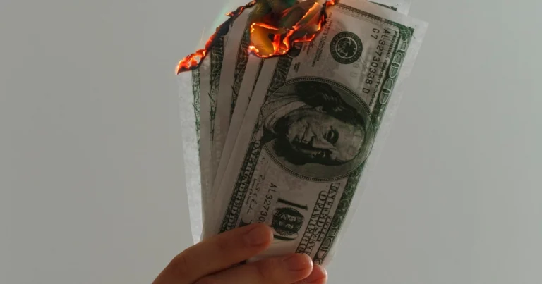 Billetes ardiendo representando el presupuesto publicitario malgastado por errores de tracking en Google Ads